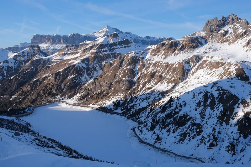 Lake Fedaia and the Padon ridge (Padonkamm - Crepes de Padon) in winter. Forcella Porta Vescovo (saddle) and La Mesola rocks. In background Piz Boe, Sella group.